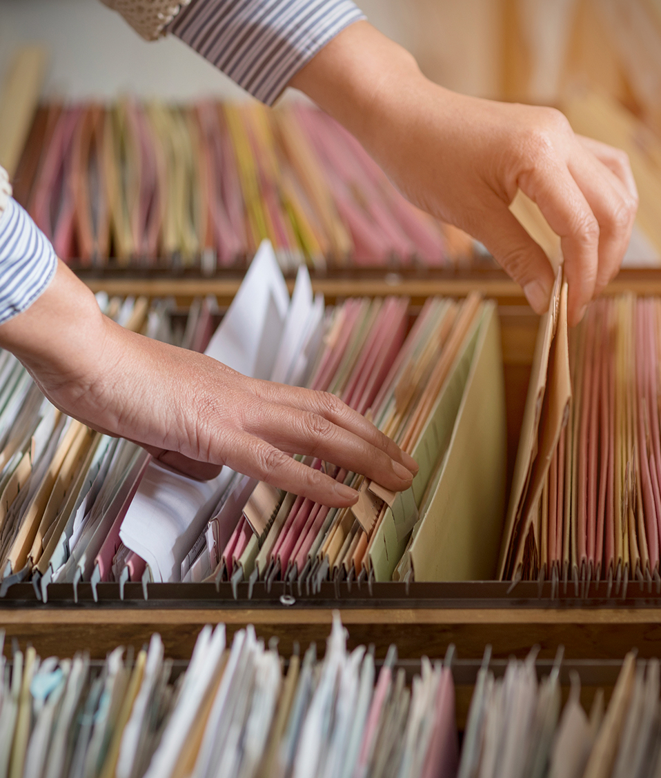 Persona buscando documentos en un cajón-archivador